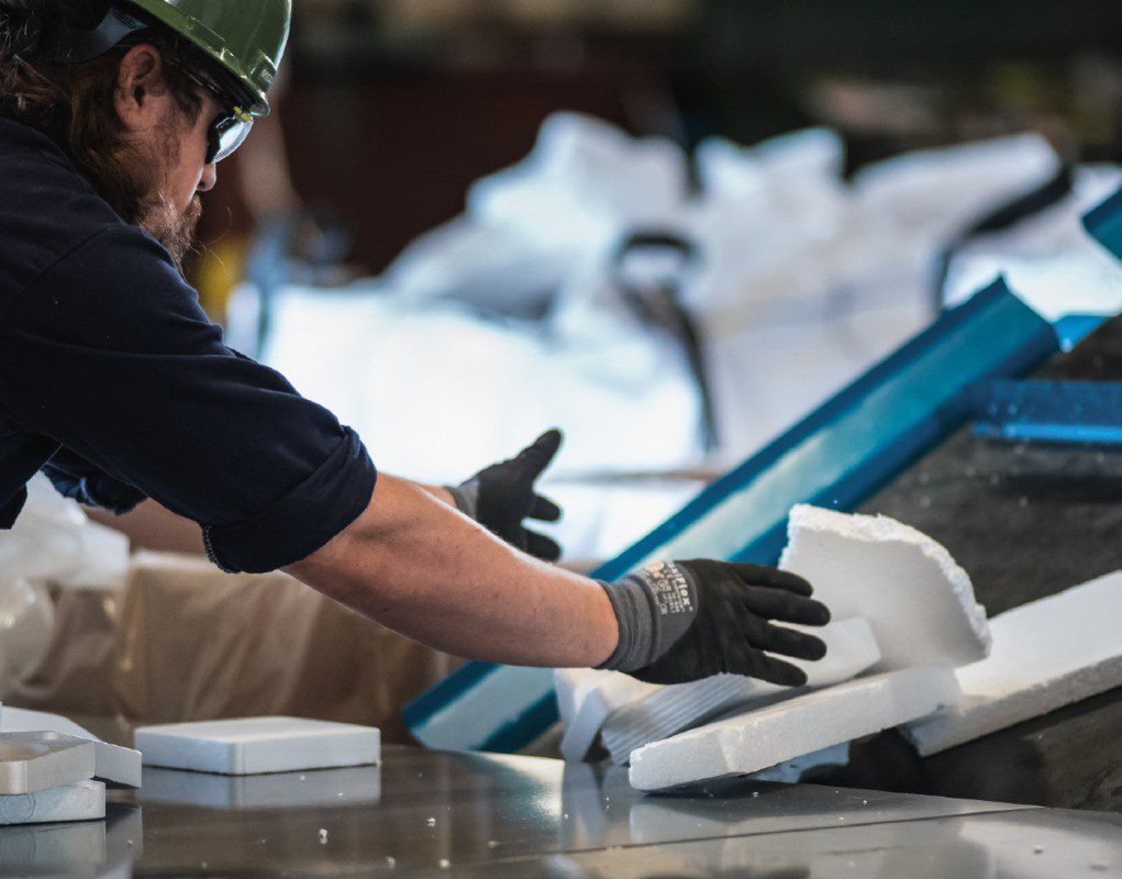 An Agilyx employee handling waste styrofoam in a chemical recycling facility with advanced plastic recycling technology in Tigard, Oregon