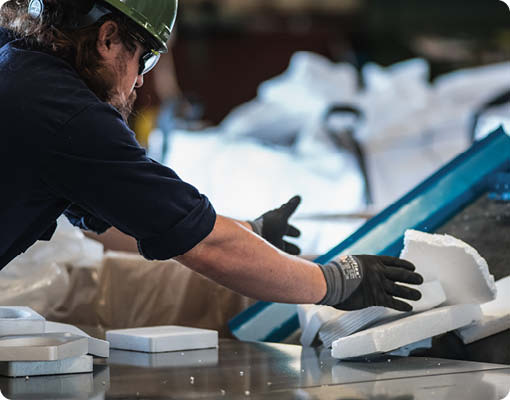 An Agilyx employee handling waste styrofoam in a chemical recycling facility with advanced plastic recycling technology in Tigard, Oregon.